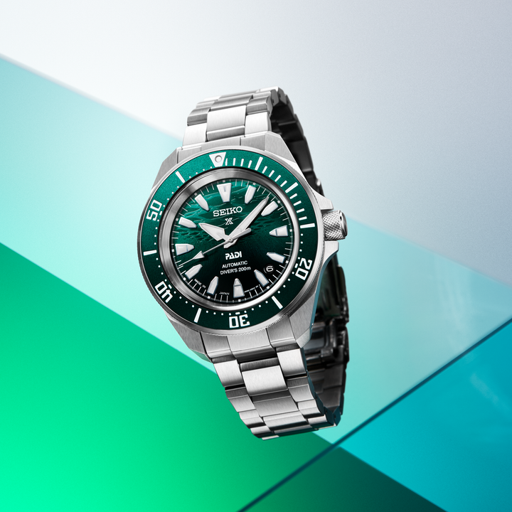 Seiko SRPL53 green-dial PADI diver displayed against a green backdrop